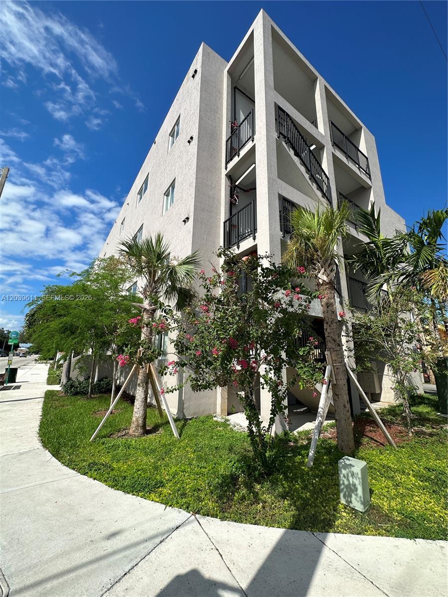 An aerial view shows a multi-story apartment building highlighted in green near a city skyline — 2311 NW 22nd Ave # 406, Miami FL 33142, MIAMI, FL