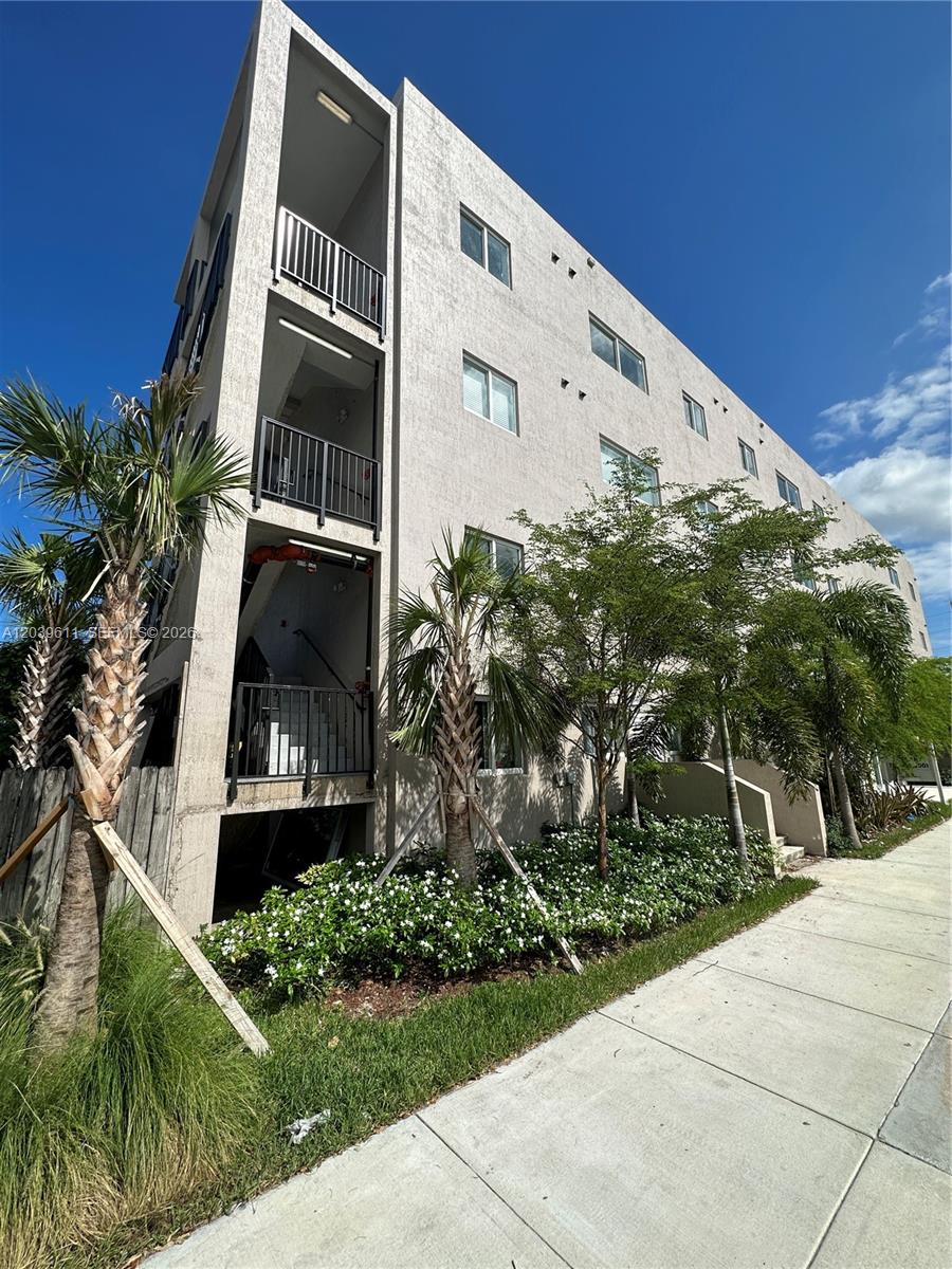 An aerial view of a multi-story apartment building with a flat roof and exterior stairwells — 2311 NW 22nd Ave # 406, Miami FL 33142, MIAMI, FL