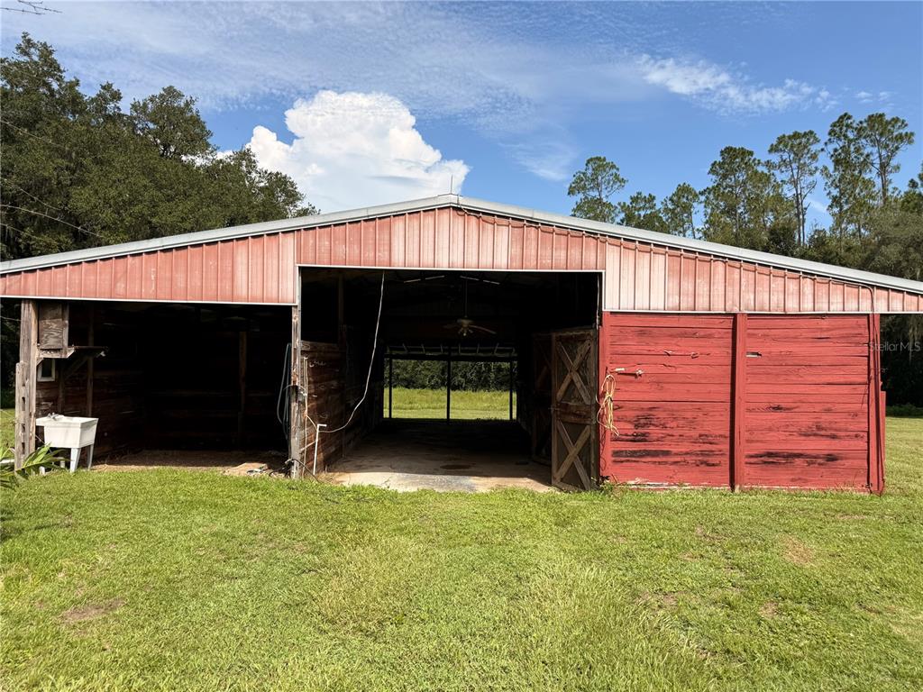 A single-story yellow house with a wrap-around porch sits on a large grassy lawn — 34951 EASTERLING ROAD, DADE CITY, FL