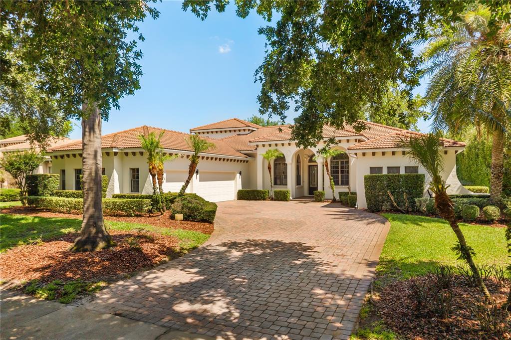 A single-story stucco house with a tile roof and a brick paver driveway — 11015 HAWKSHEAD COURT, WINDERMERE, FL