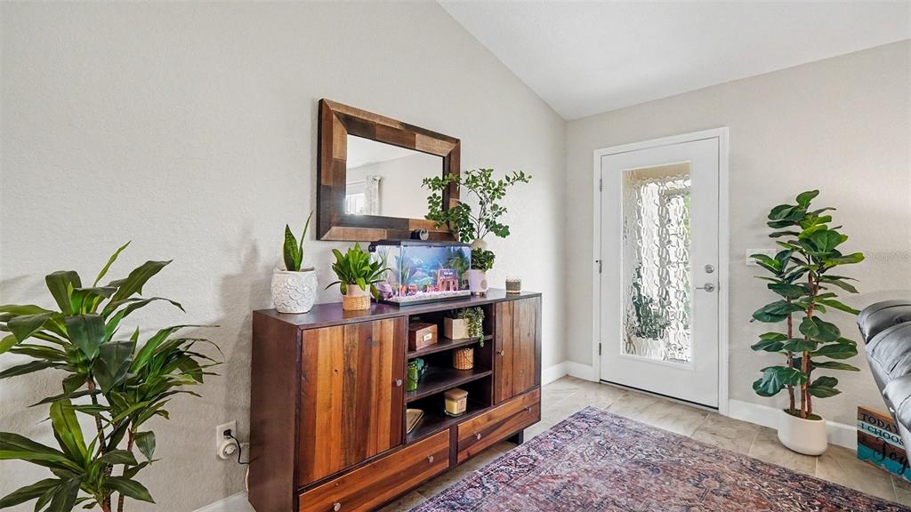 A wooden console table with a fish tank sits in a room with a door — 6548 SW 131ST PLACE, OCALA, FL