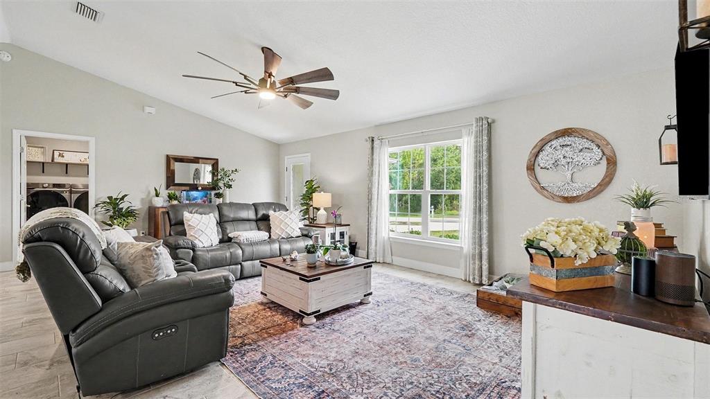A living room features gray leather seating, a white coffee table, and a patterned rug — 6548 SW 131ST PLACE, OCALA, FL