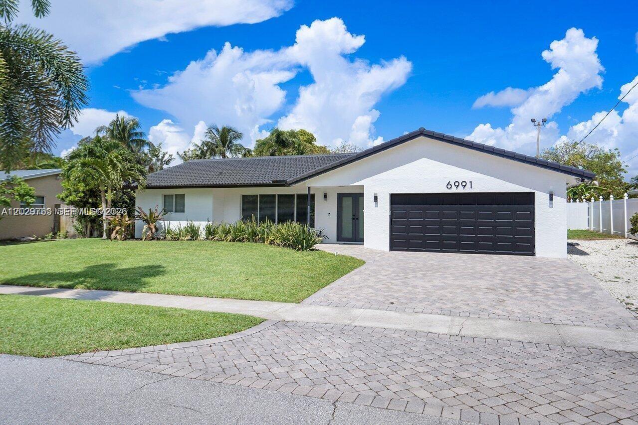 A single-story house features a white exterior, a black roof, and a paved driveway — 6991 NE 7th Ave # 0, Boca Raton FL 33487, BOCA RATON, FL
