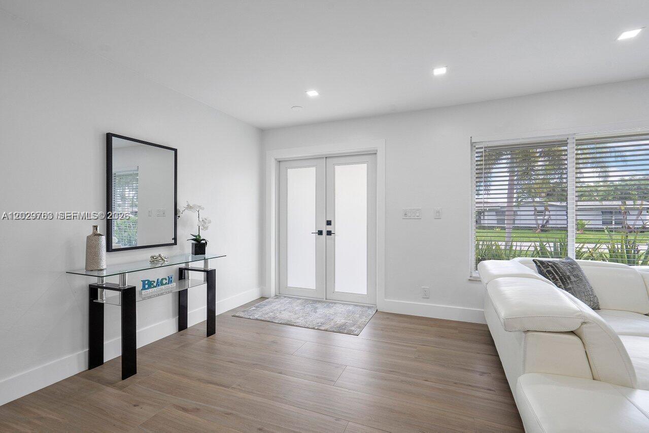 A bright entryway features a glass console table, a mirror, and double doors — 6991 NE 7th Ave # 0, Boca Raton FL 33487, BOCA RATON, FL