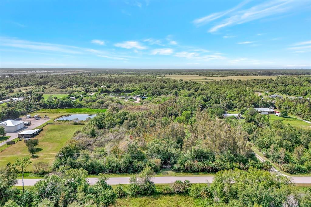 An aerial view of a wooded lot with a road in the foreground — 41601 LITTLE FARM ROAD, PUNTA GORDA, FL