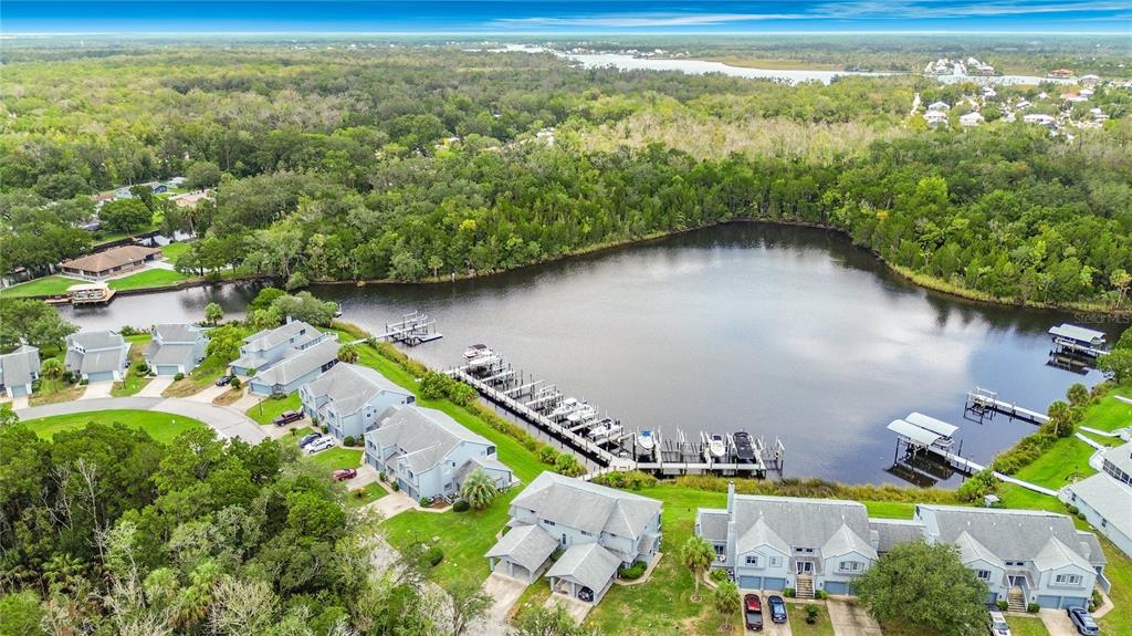 An aerial view shows a residential complex with a private boat dock on a lake — 11122 W COVE HARBOR DRIVE UNIT 112, CRYSTAL RIVER, FL