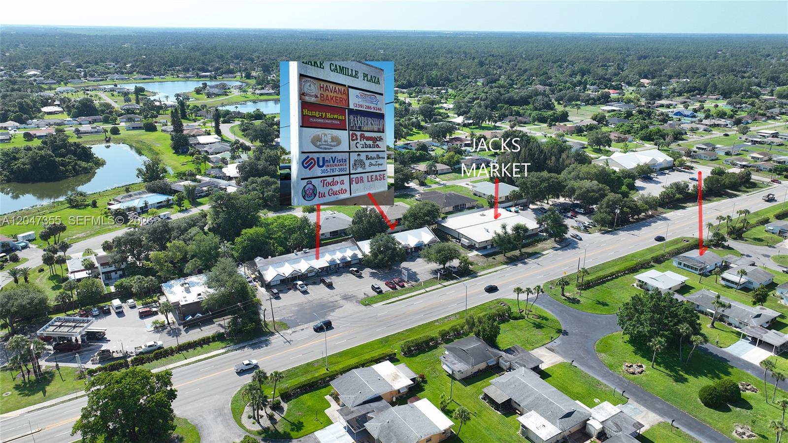 An aerial view shows a commercial plaza with a sign and nearby residential houses — 2201 Croton Ct., Lehigh Acres FL 33936, LEHIGH ACRES, FL