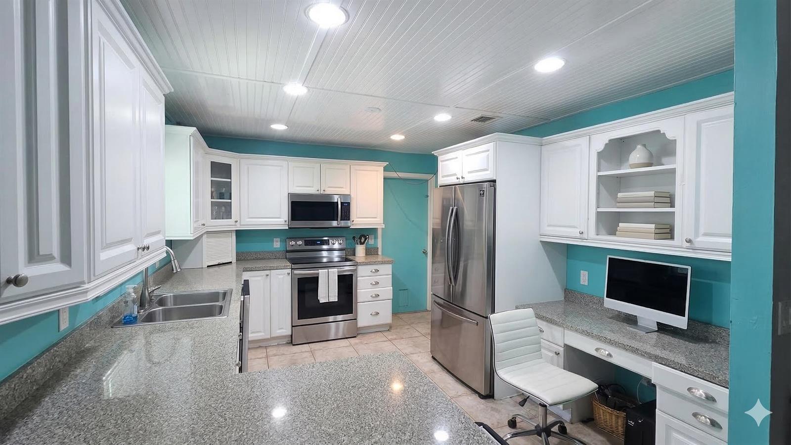 A kitchen with white cabinets, granite countertops, stainless steel appliances, and turquoise walls — 5679 Sims Road, Delray Beach FL 33484, DELRAY BEACH, FL