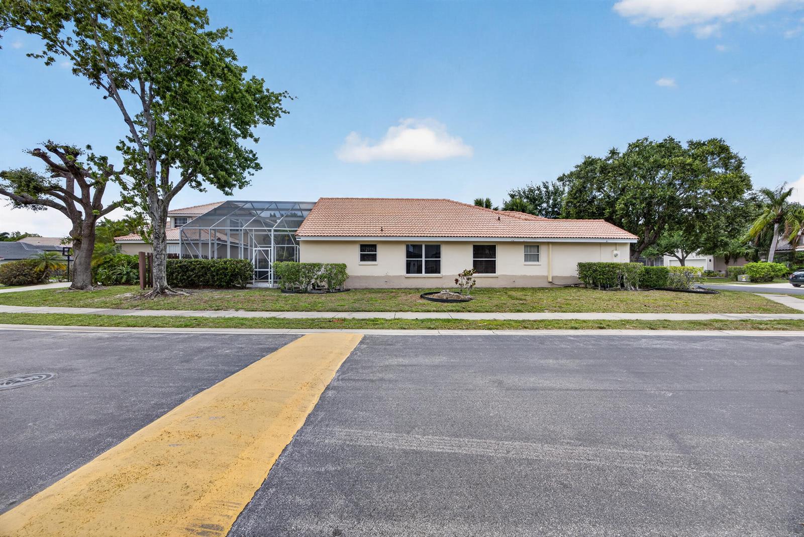 A single-story house with a tiled roof and a screened-in patio faces a street — 10870 Old Bridgeport Lane, Boca Raton FL 33498, BOCA RATON, FL