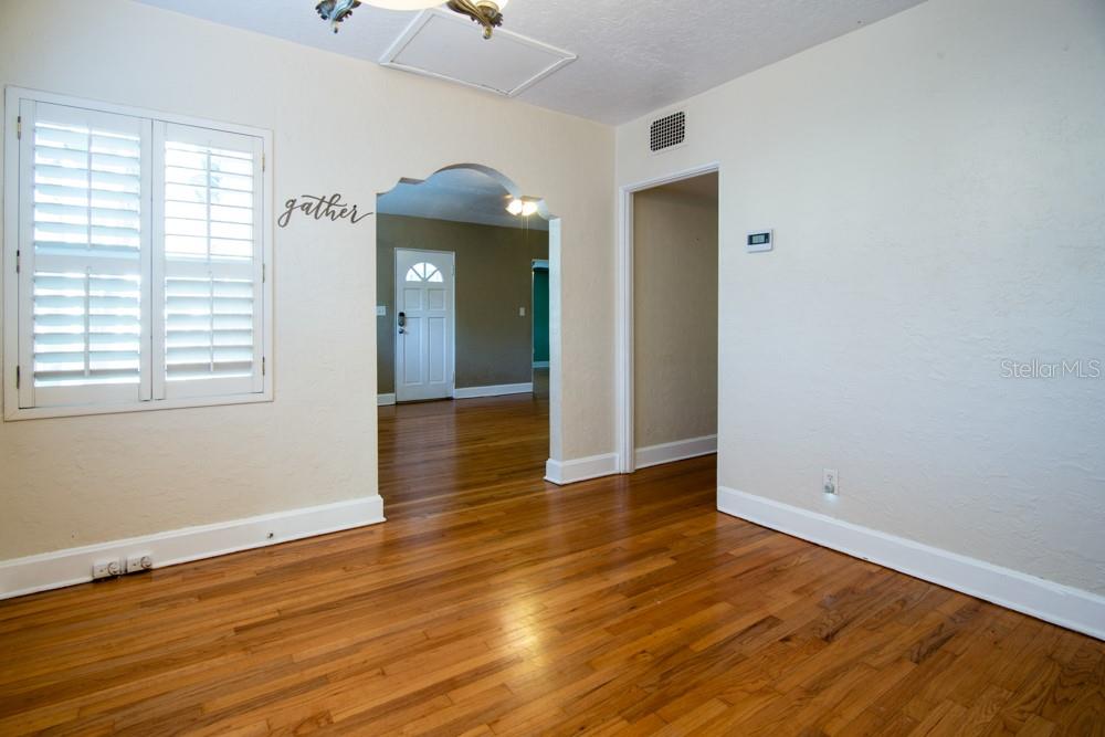 A room with hardwood floors, an arched doorway, and a window with white shutters — 1840 BAYLARIAN BOULEVARD, ORLANDO, FL