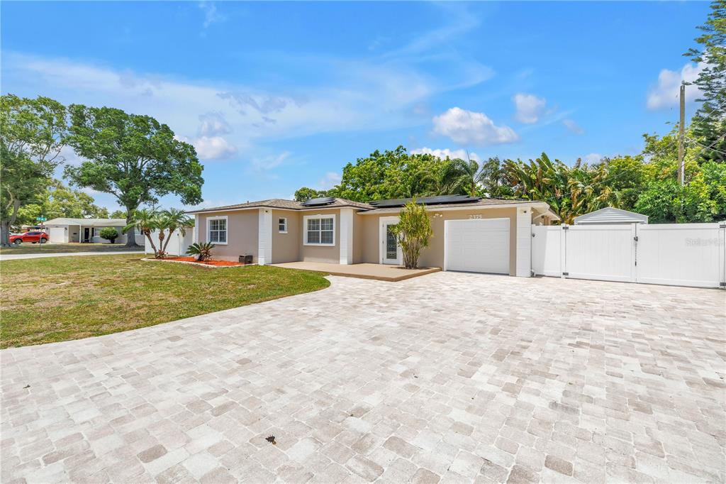 A single-story house with a paved driveway, white garage door, and a white fence — 2375 37TH STREET N, ST PETERSBURG, FL