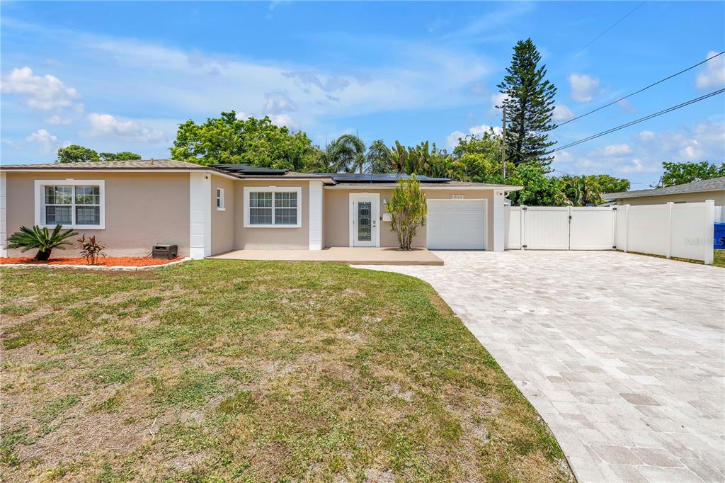 A single-story house with a paved driveway, white garage door, and a white vinyl fence — 2375 37TH STREET N, ST PETERSBURG, FL