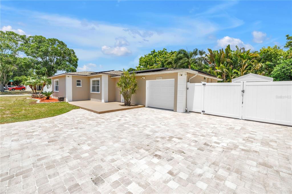 A single-story house with a paved driveway, a white garage door, and a white fence — 2375 37TH STREET N, ST PETERSBURG, FL