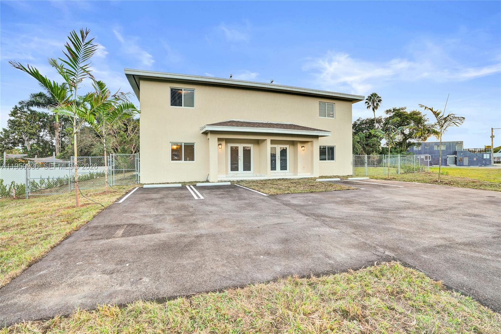 A two-story beige building features a paved parking lot and a chain-link fence — 250 NE 119th Terrace, Miami FL 33161, MIAMI, FL