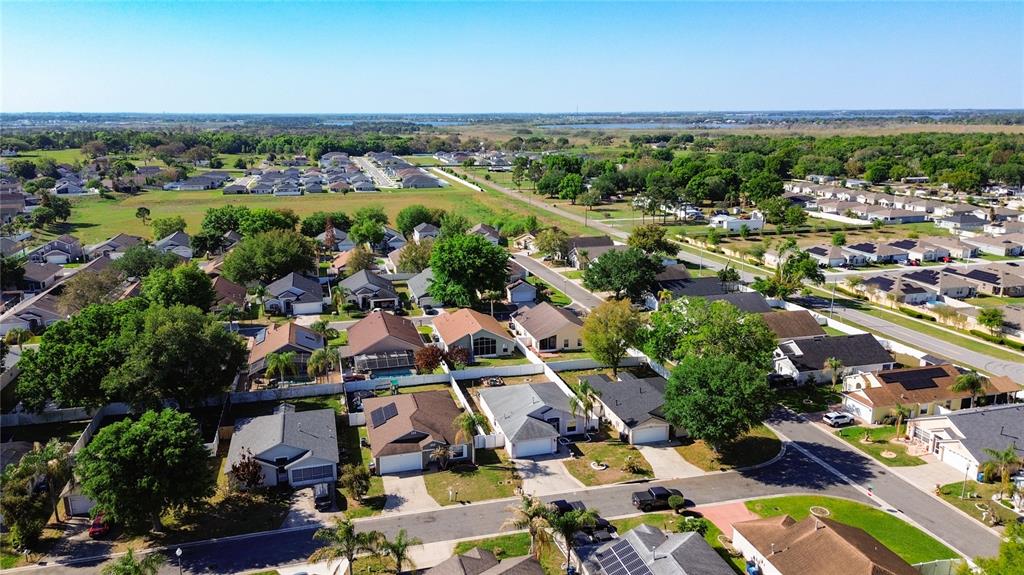 An aerial view of a suburban neighborhood featuring single-family homes with driveways and green lawns — 233 VERBENA STREET, DAVENPORT, FL