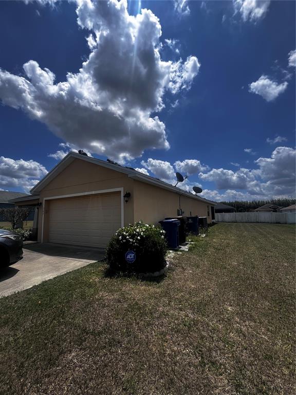 A kitchen with dark cabinets and an island overlooks a carpeted living area — 167 8TH STREET, LAKE HAMILTON, FL