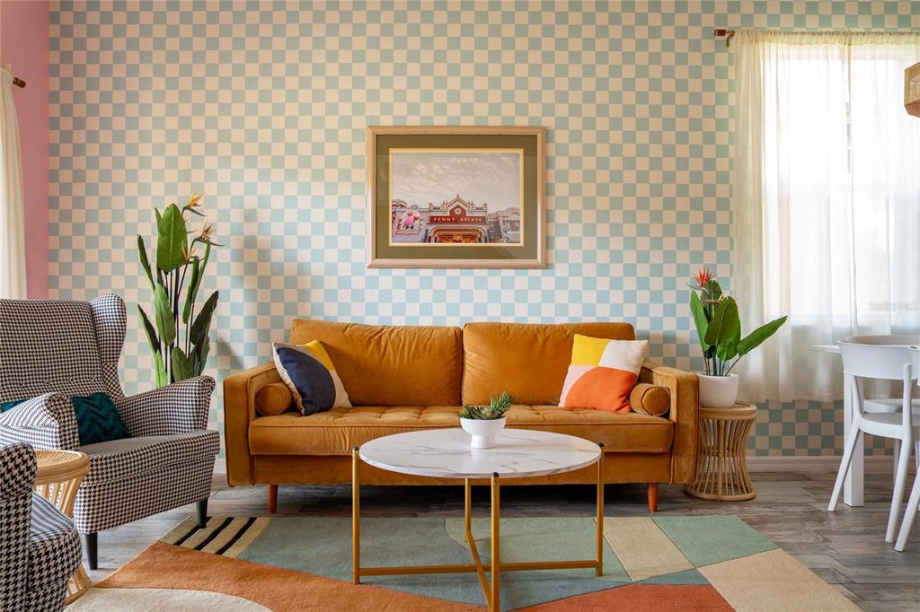 A living room features a mustard sofa, checkered wallpaper, a marble coffee table, and patterned chairs — 2735 CALABRIA AVENUE, DAVENPORT, FL