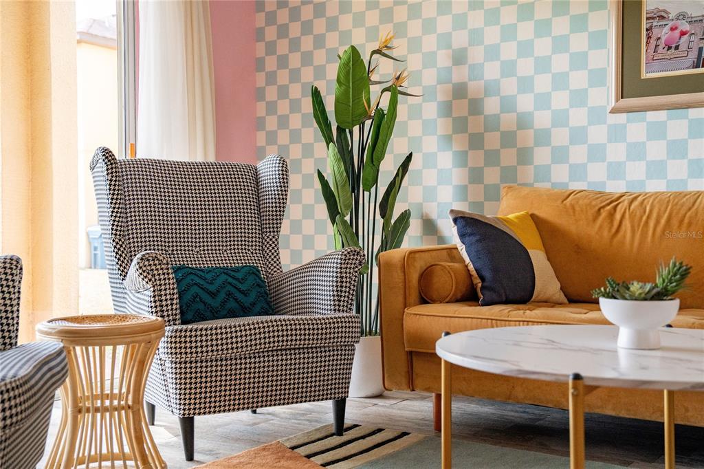 A living room features a houndstooth wingback chair, a yellow sofa, and checkered wallpaper — 2735 CALABRIA AVENUE, DAVENPORT, FL