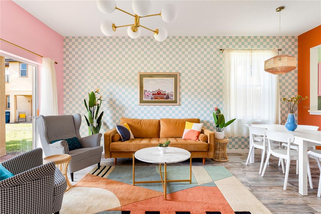 A living and dining area features a checkered accent wall, mustard sofa, and patterned rug — 2735 CALABRIA AVENUE, DAVENPORT, FL