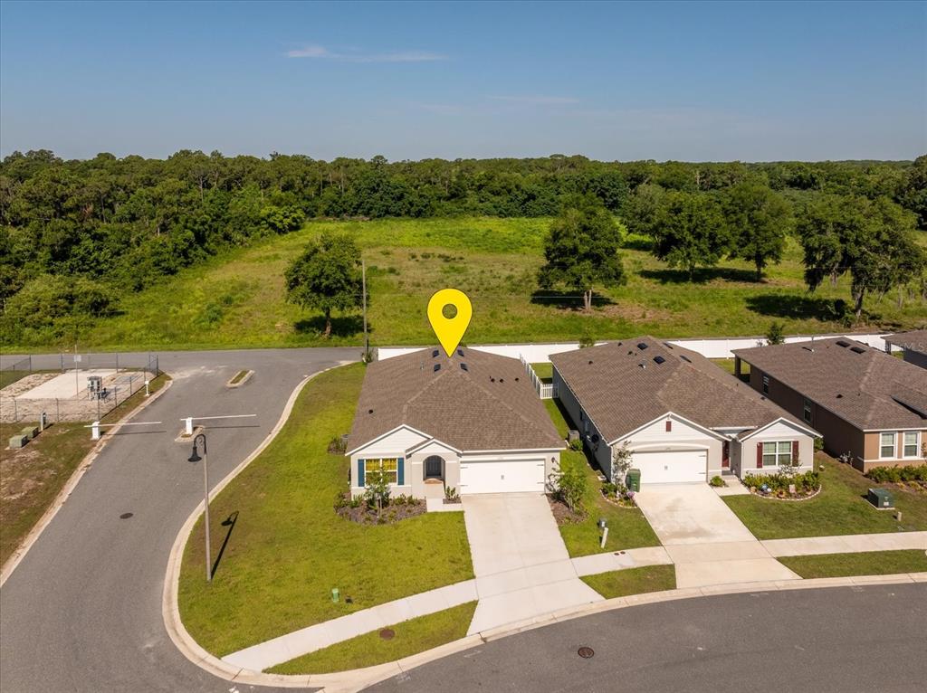 An aerial view shows a suburban house with a gray roof and attached garage — 6358 SANDERS GROVE CIRCLE, OKAHUMPKA, FL