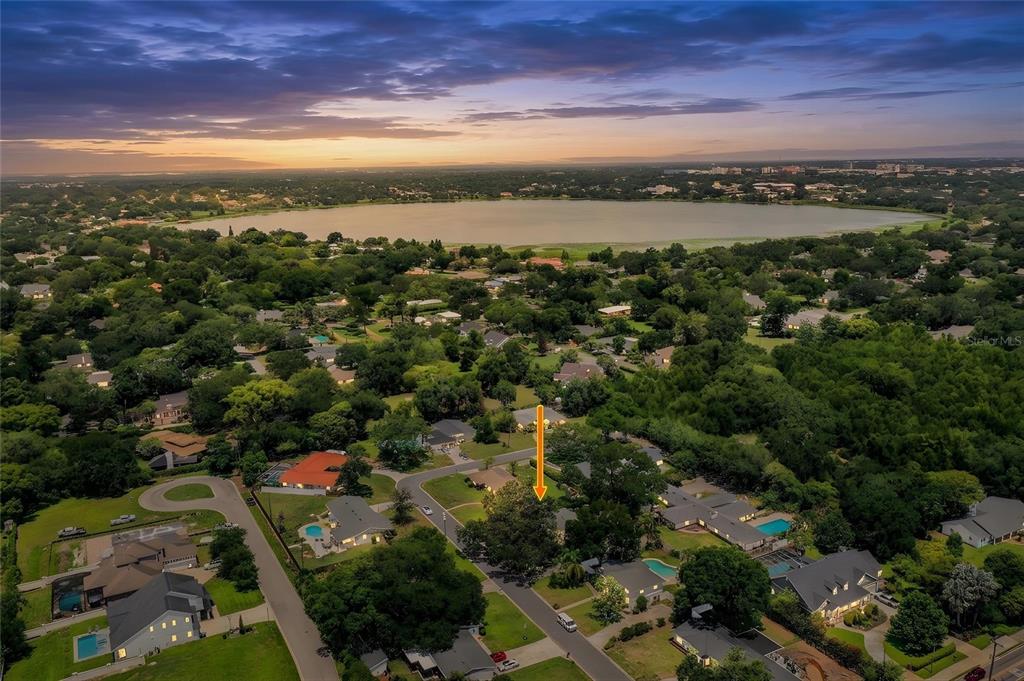 An aerial view shows a residential neighborhood with a house marked by an orange arrow — 1522 DEL CREST PLACE, LAKELAND, FL