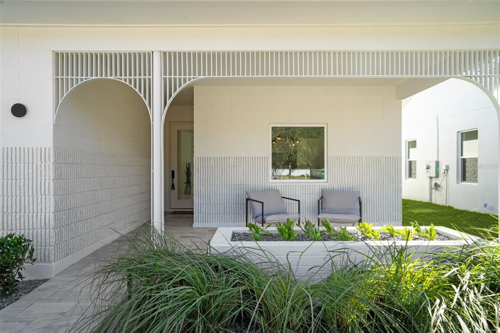 A covered front porch features white block walls, a decorative screen, and a built-in planter — 438 SKYFIELD COURT, LADY LAKE, FL