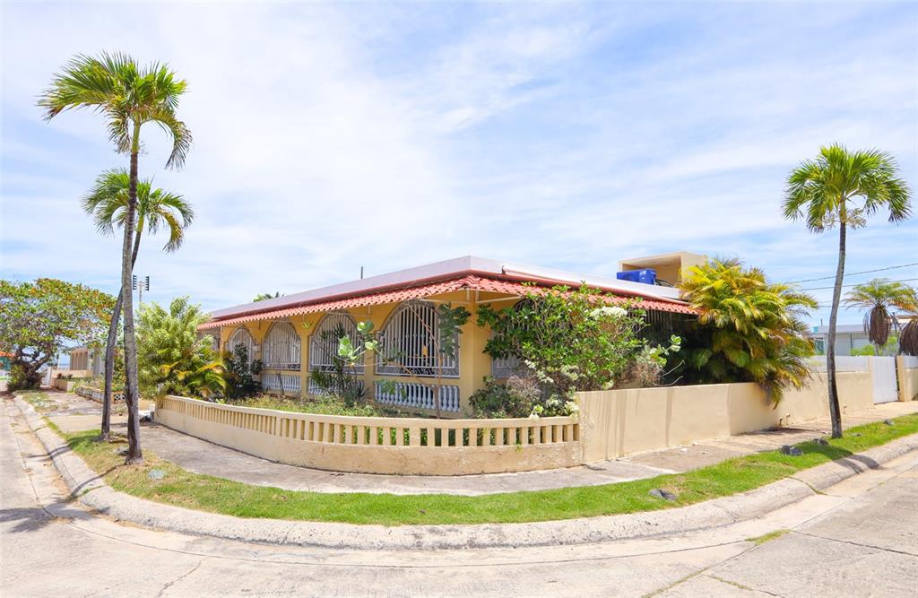 A yellow single-story house with a red tile roof and arched windows behind security bars — D-1 HATILLO DEL MAR, HATILLO, PR