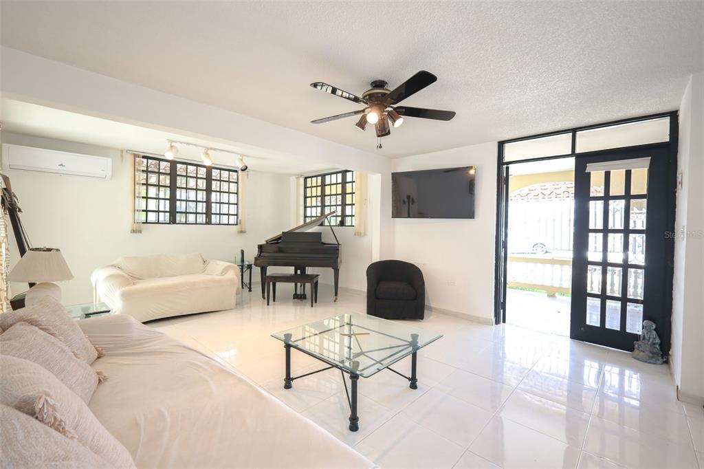 A living room features white tile floors, a grand piano, and a glass coffee table — D-1 HATILLO DEL MAR, HATILLO, PR
