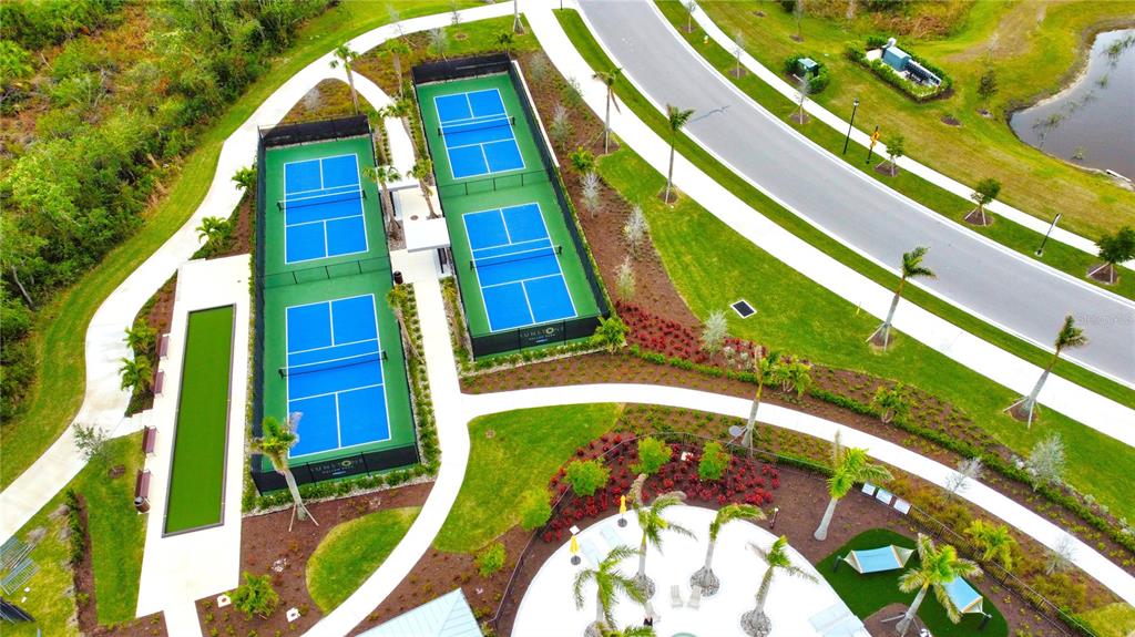 An aerial view shows two fenced pickleball courts next to a paved path and landscaping — 17784 STILLNESS COURT, VENICE, FL