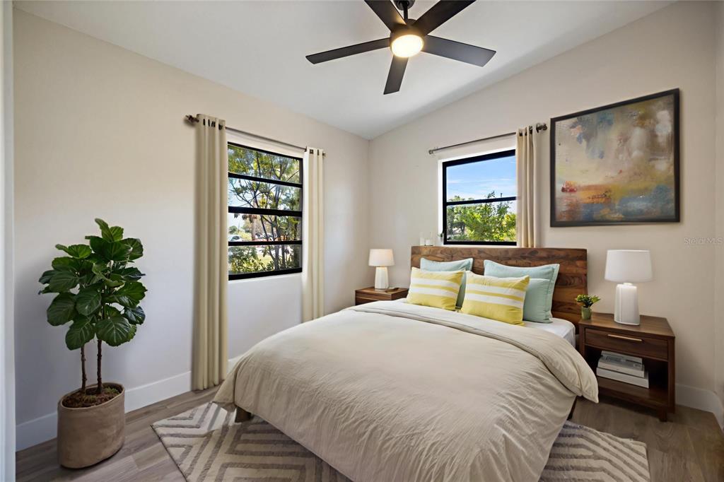 A bedroom features a bed, two windows, a ceiling fan, and a potted plant — 11014 58TH STREET N, PINELLAS PARK, FL