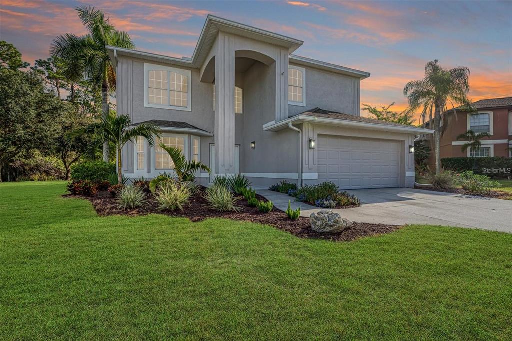 A two-story suburban house with a two-car garage, light gray exterior, and landscaped front yard — 4705 78TH COURT E, BRADENTON, FL