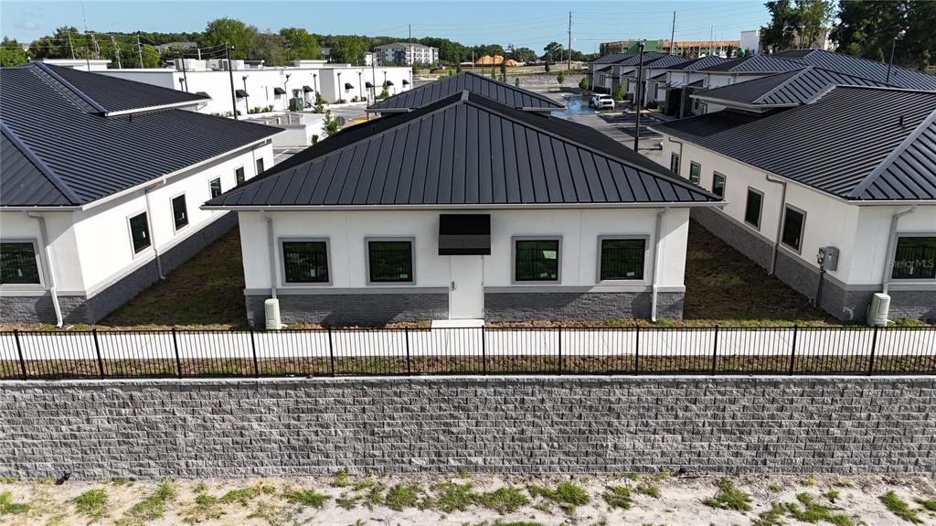 An exterior view of a modern single-story commercial building with a black metal roof — 2805 OCOEE APOPKA ROAD UNIT 12, APOPKA, FL