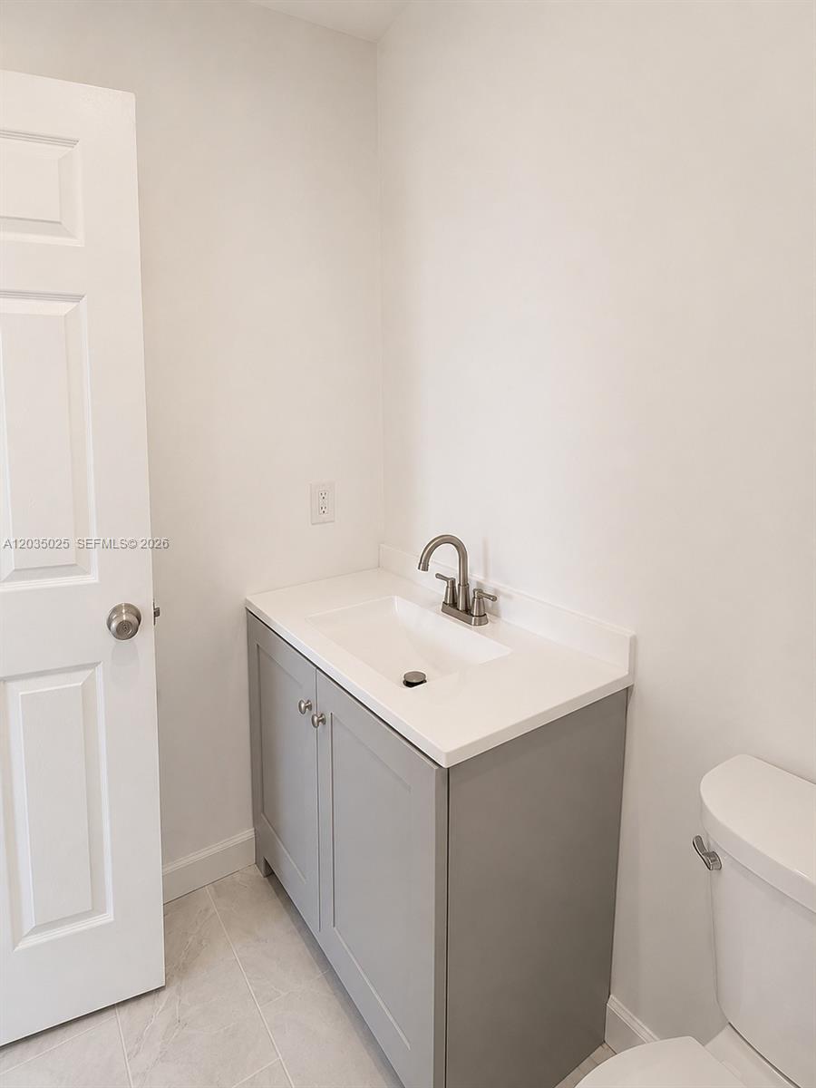 A bathroom features a gray vanity with a white countertop, a sink, and a toilet — 11931 SW 132nd Ave, Miami FL 33186, MIAMI, FL