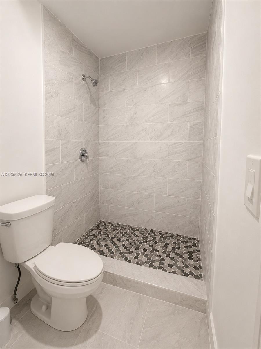 A bathroom features a walk-in shower with gray marble-look tile and a hexagonal tile floor — 11931 SW 132nd Ave, Miami FL 33186, MIAMI, FL