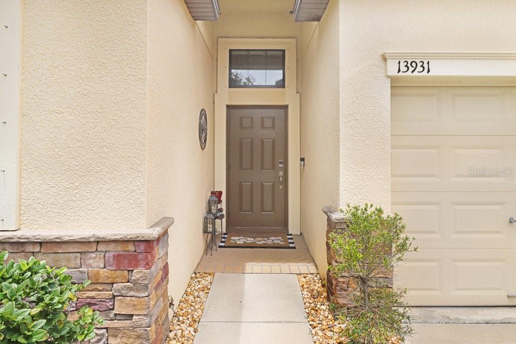 A front entryway features a brown door, a transom window, and a stone-accented exterior wall — 13931 FELIX WILL ROAD, RIVERVIEW, FL