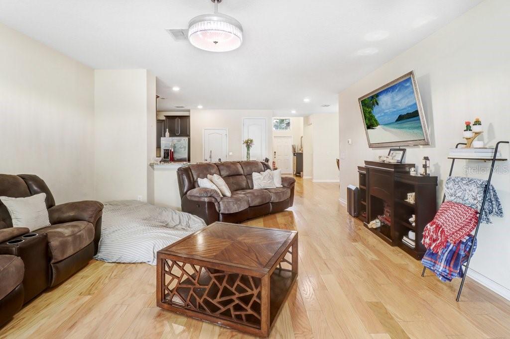 A living room features brown leather furniture, a wooden coffee table, and light wood flooring — 13931 FELIX WILL ROAD, RIVERVIEW, FL
