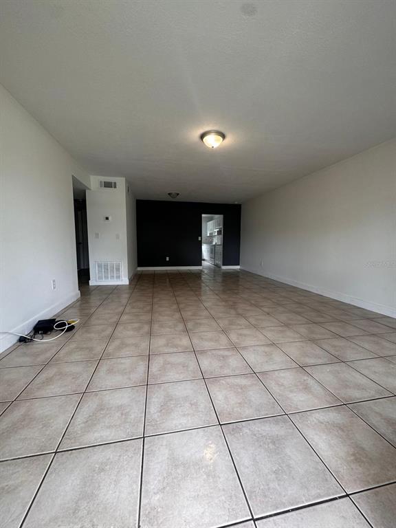 An empty room features light-colored tile flooring, white walls, and a dark accent wall — 725 NORTHLAKE BOULEVARD UNIT 38, ALTAMONTE SPRINGS, FL