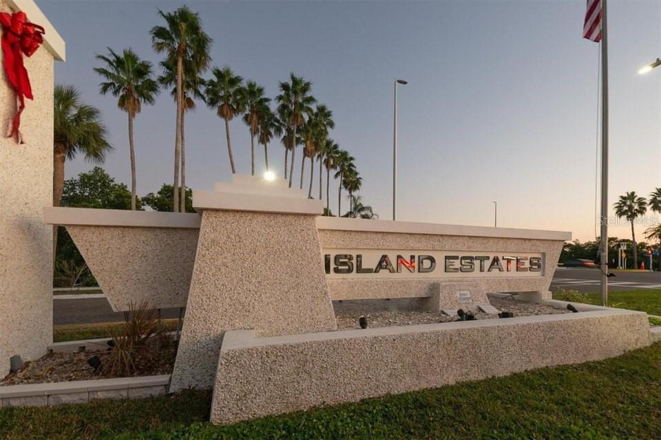 A stone monument sign for Island Estates stands outdoors with palm trees in the background — 51 ISLAND WAY UNIT 801, CLEARWATER BEACH, FL
