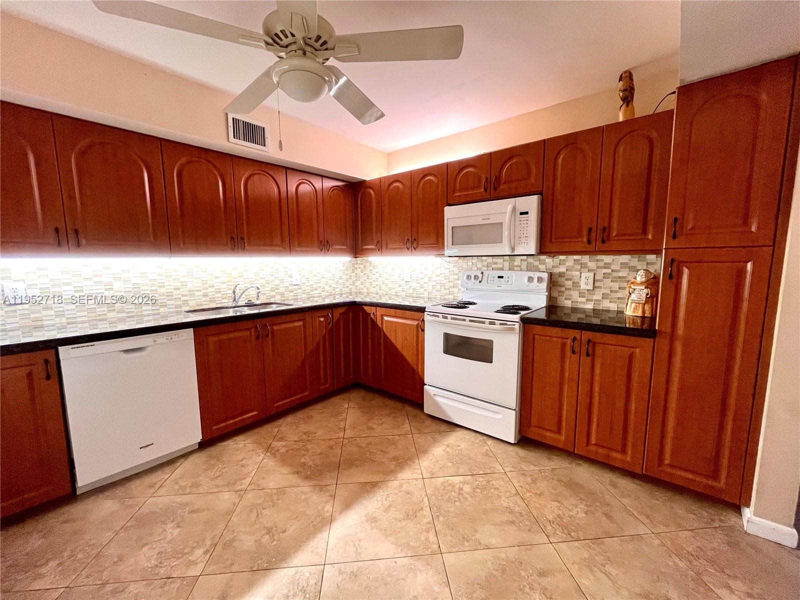 A room with beige walls, tiled floors, double closet doors, and a large potted plant — 2806 N 46th Ave # D537, Hollywood FL 33021, HOLLYWOOD, FL