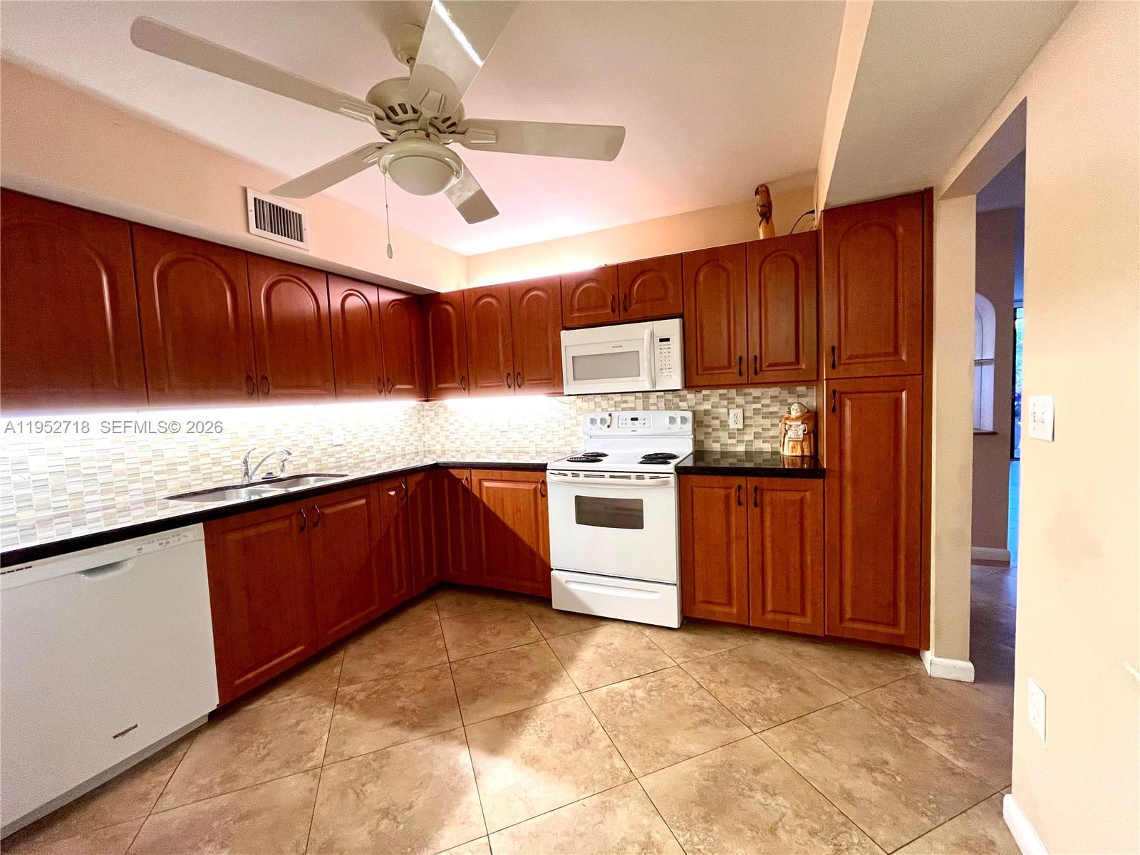 A tiled living area features a dining set and sliding glass doors to a balcony — 2806 N 46th Ave # D537, Hollywood FL 33021, HOLLYWOOD, FL