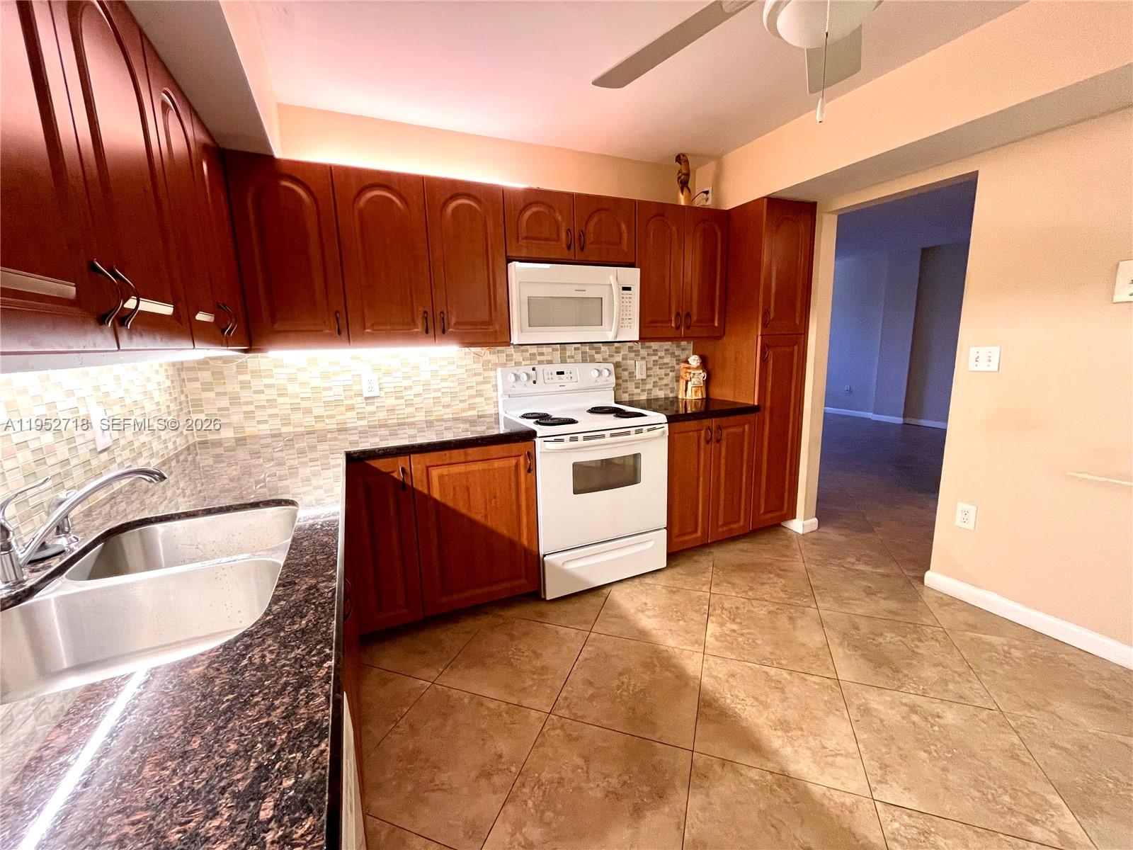 A tiled entryway leads to a living area with an arched cutout and glass doors — 2806 N 46th Ave # D537, Hollywood FL 33021, HOLLYWOOD, FL
