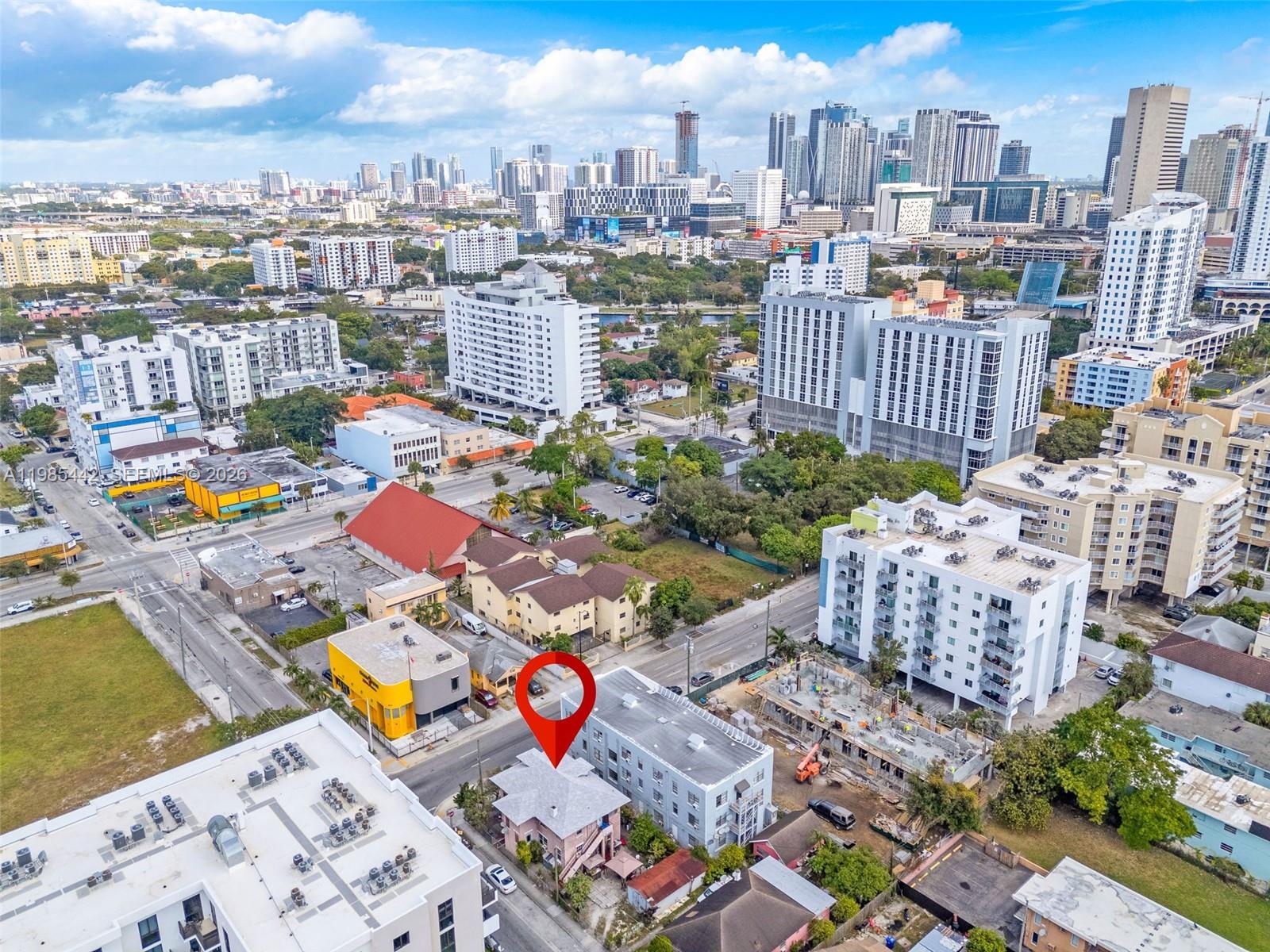 An aerial view shows a pink building marked with a red pin in a city — 676 SW 1st St, Miami FL 33130, MIAMI, FL