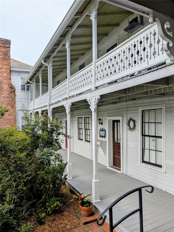 A two-story white wooden building features a long covered porch with decorative railings — 6635 SE 221ST STREET UNIT 2, HAWTHORNE, FL