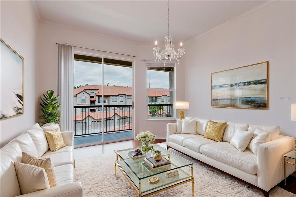 A living room features white leather sofas, a glass coffee table, and a balcony view — 18107 PEREGRINES PERCH PLACE UNIT 6303, LUTZ, FL