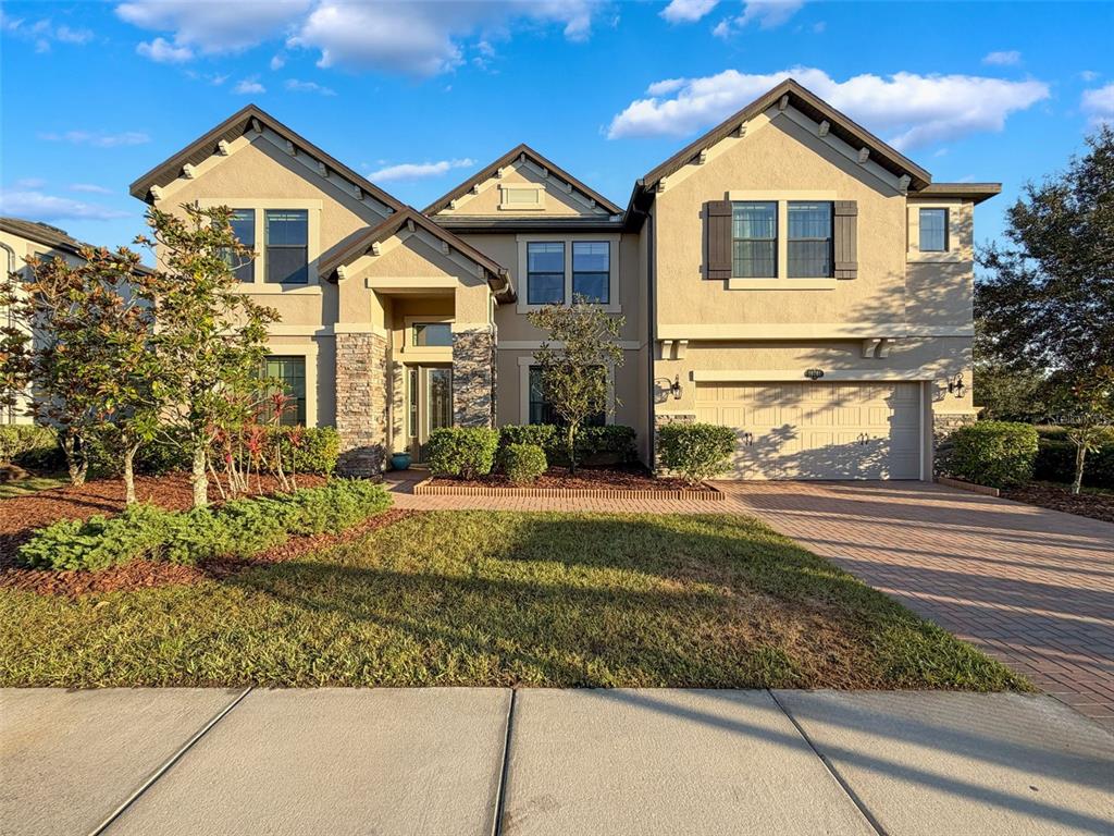 A two-story suburban house with a stone-accented entryway, stucco exterior, and a two-car garage — 10701 LAUREL VISTA WAY, TAMPA, FL