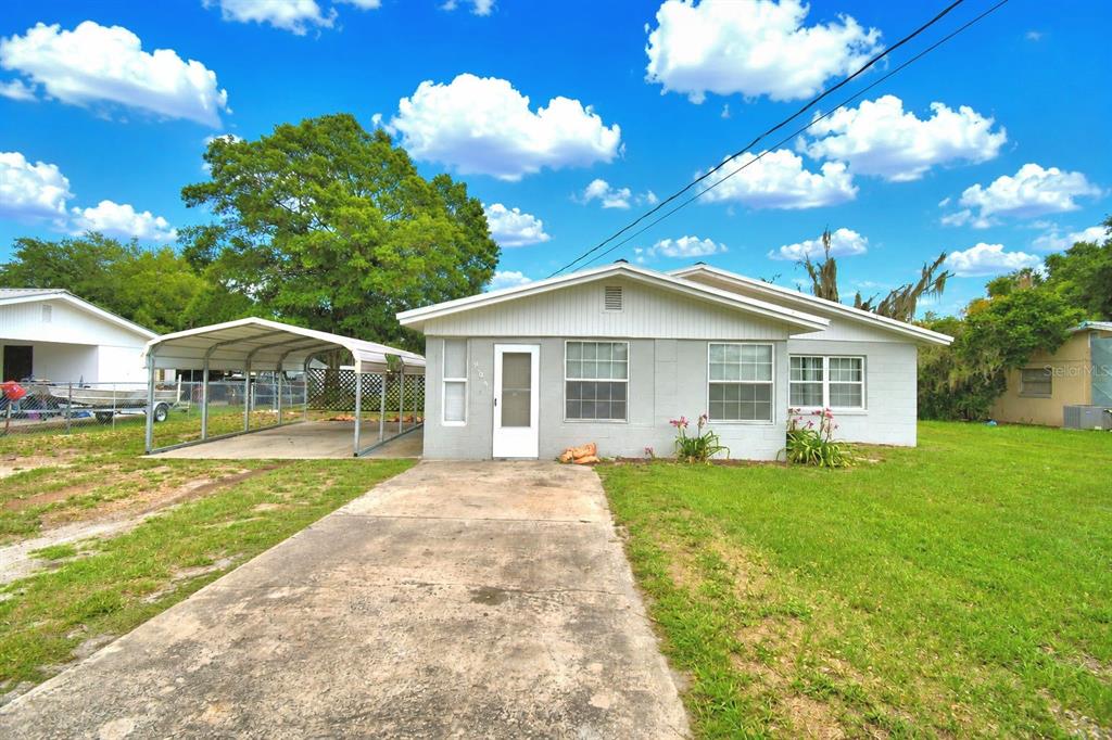 A single-story gray house with a metal carport and a concrete driveway — 906 N 9TH AVENUE, WAUCHULA, FL