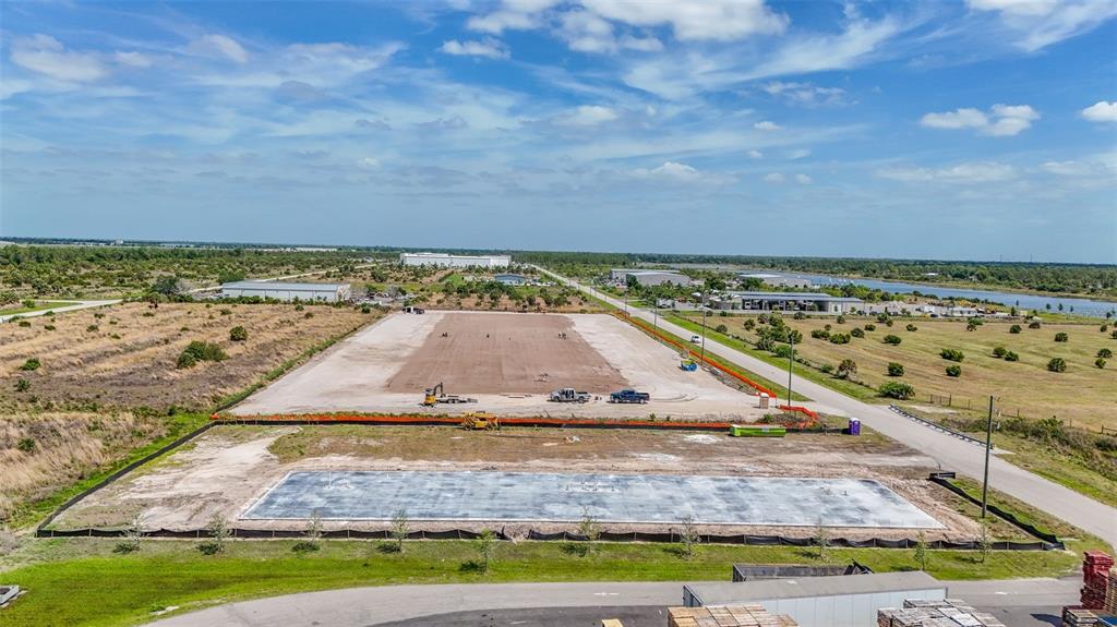 An aerial view shows a rectangular concrete foundation slab on a cleared construction lot — 8429 NORTHUP DRIVE UNIT 4, PUNTA GORDA, FL