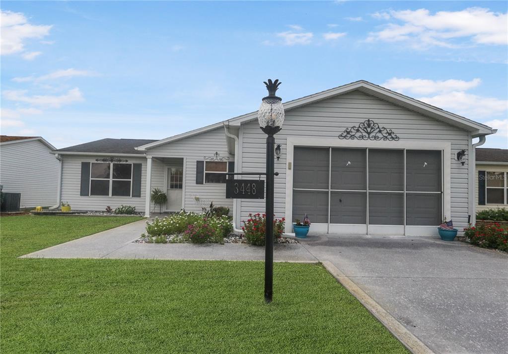 A single-story house with light gray siding, a garage, and a front lawn — 3448 JACONA PLACE, THE VILLAGES, FL