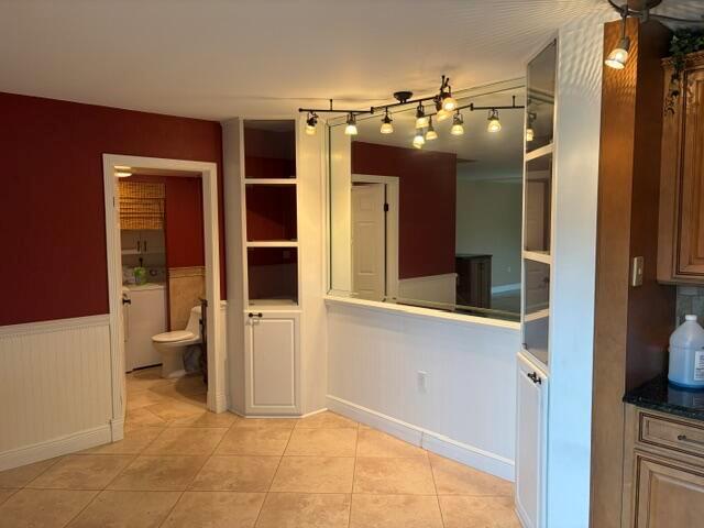 A dining area features tile flooring, a mirrored wall, built-in shelving, and a nearby bathroom — 3900 SE County Line Road # 24d, Tequesta FL 33469, TEQUESTA, FL