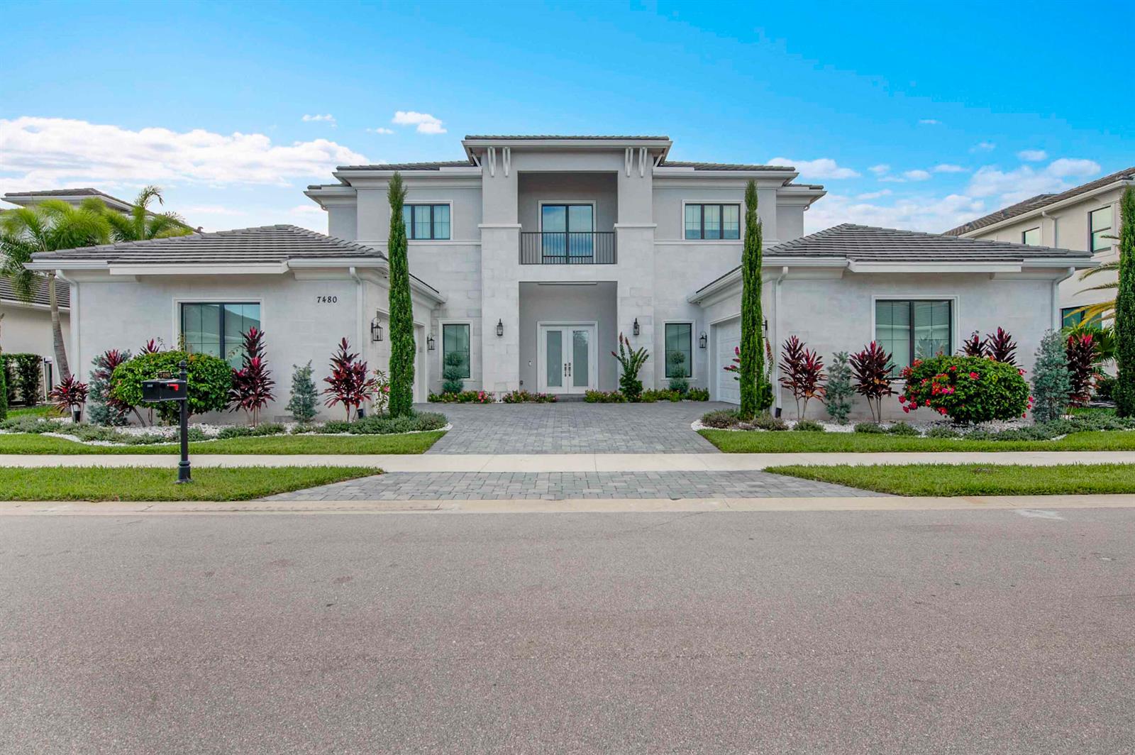 A two-story, light-colored modern house with a paved driveway and symmetrical landscaping — 7480 NW 26th Way, Boca Raton FL 33496, BOCA RATON, FL